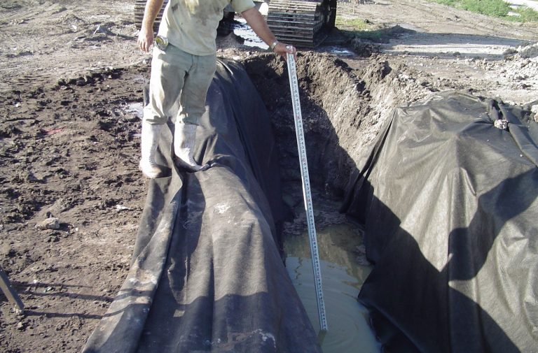 Man measuring water level with a scale